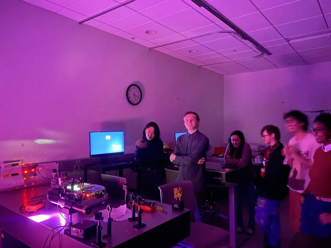 slightly blurry photo of group looking at hologram