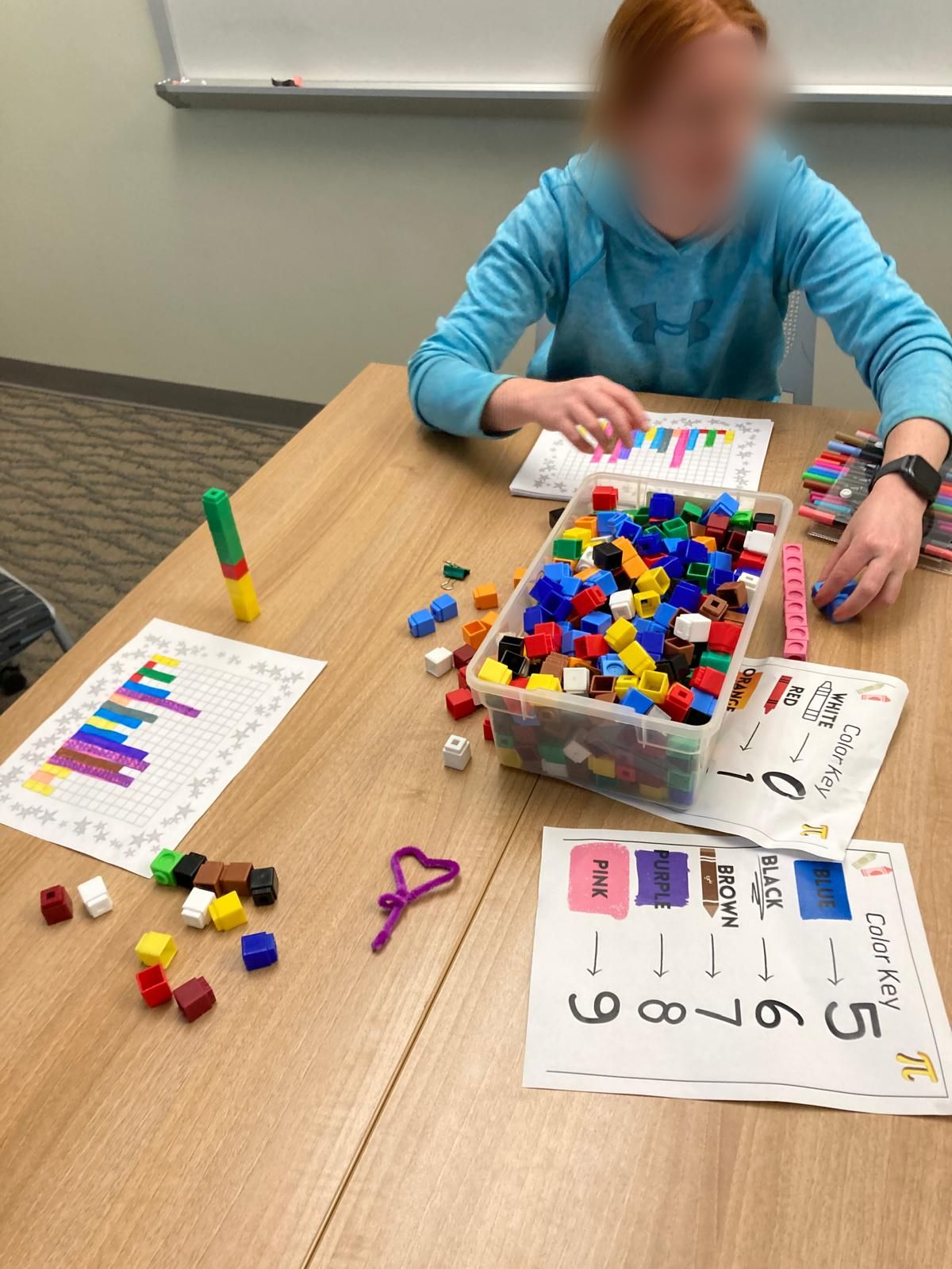 person with blocks and colouring sheet