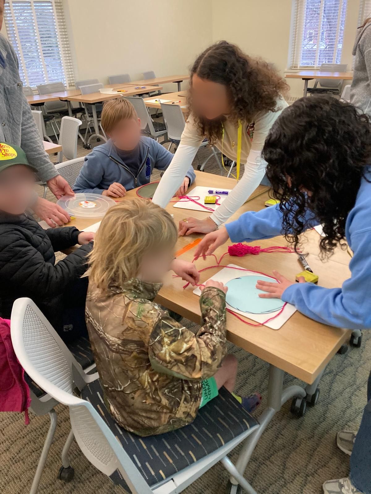 Children making circles with string and paper